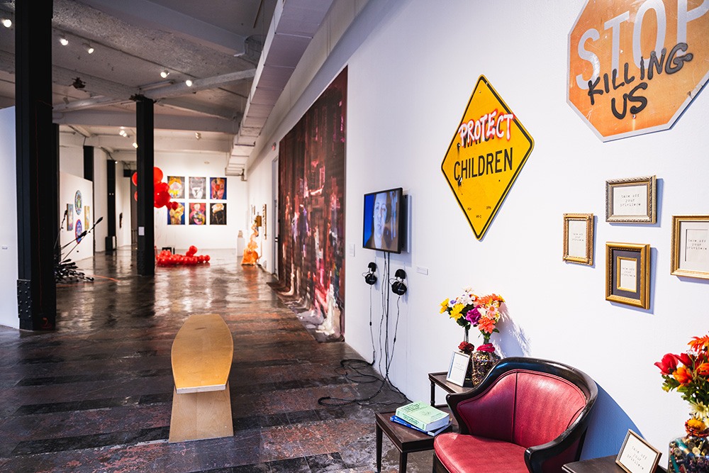 a large gallery space with murals, sculptures, paintings, and more