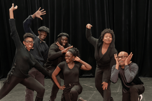 group of Black artists dressed in black and posing together