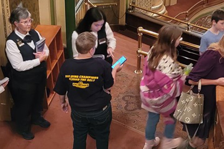  A student volunteer helps a patron find their seat in the Benedum Center.