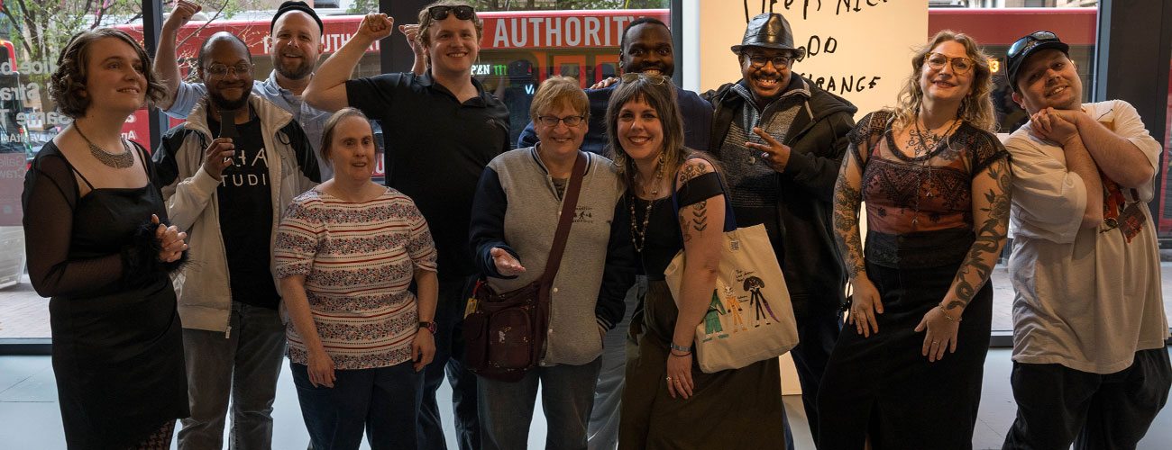 Group photo of artists posing in open gallery space.