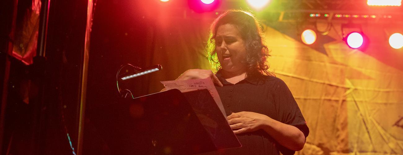 A woman using American Sign Language on stage.
