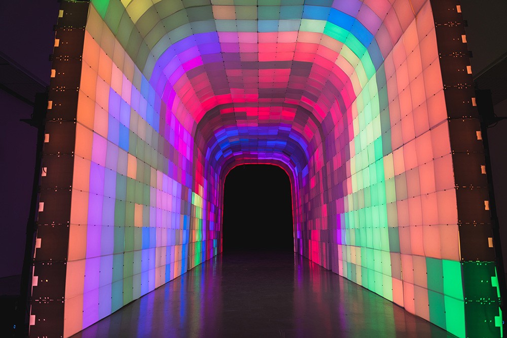a wide, arched tunnel made of multicolored light up blocks