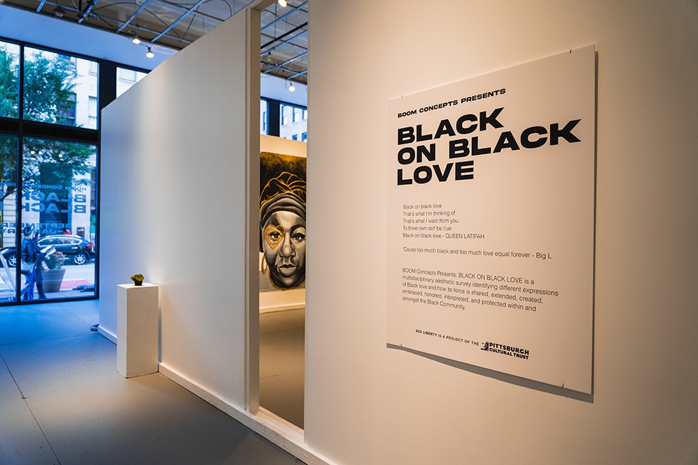 a gallery statement on a white wall in a large gallery space. the statement reads 'black on black love' with smaller descriptive text