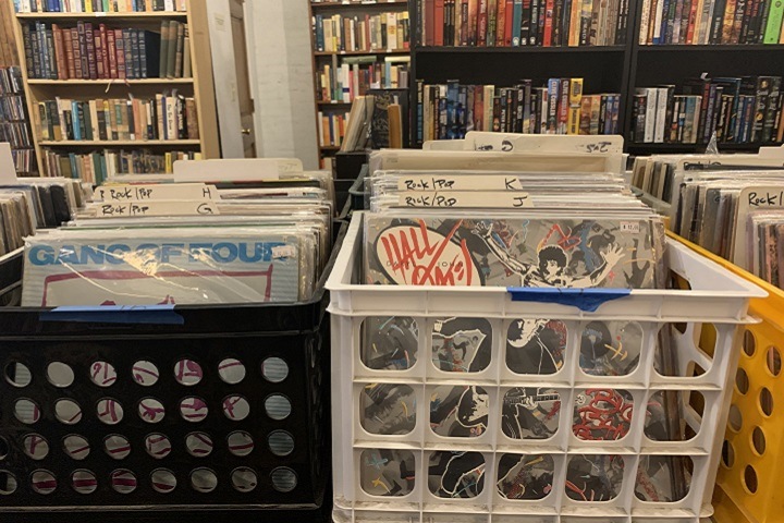 two crates of records with bookshelves in the background