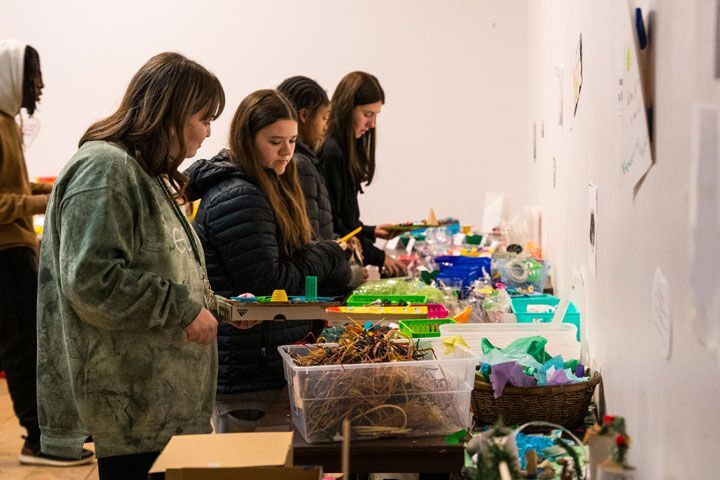 Students alongside a table with crafting supplies.