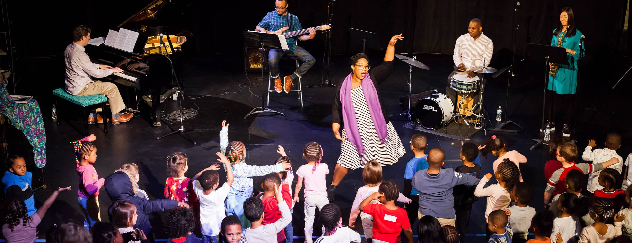 jazz musicians perform for a group of young children in the trust arts education center