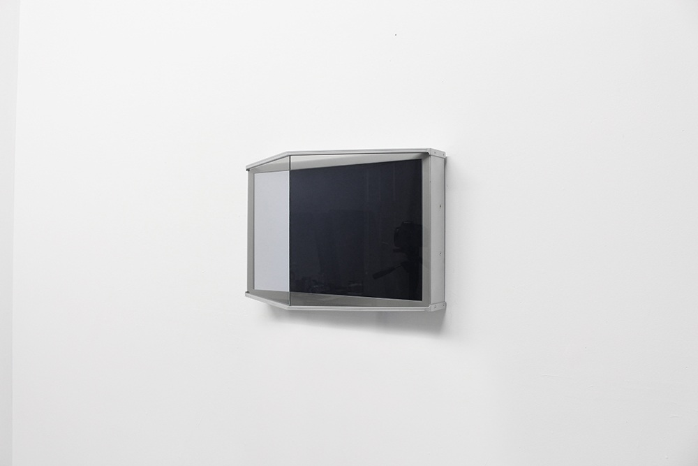 a metal and glass mirrored box hanging on a white wall