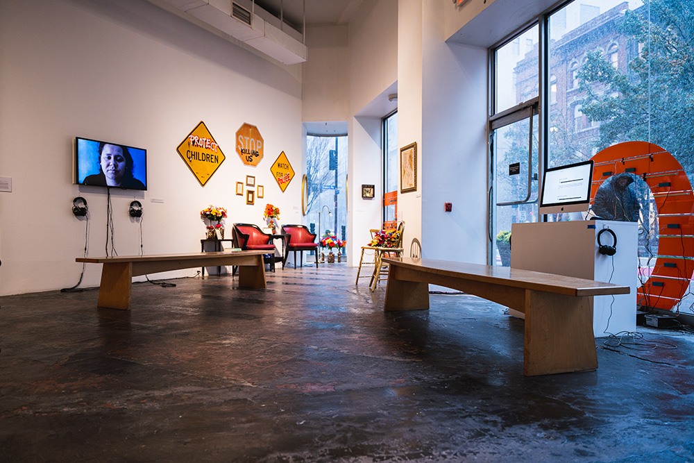 two wooden benches sit in front of screens.