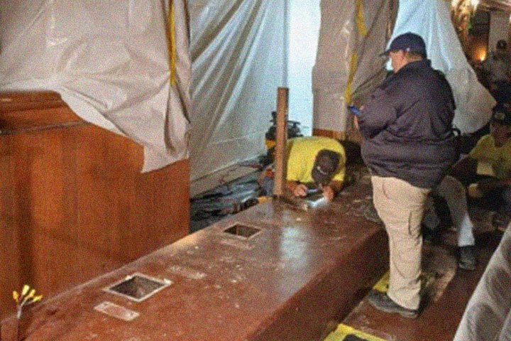 Construction workers work on stripping down the stair riser for the new seating.